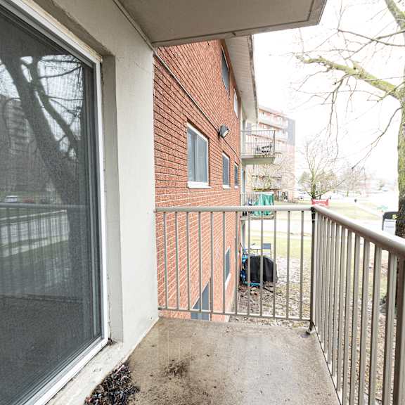 a balcony with a metal railing and a glass door.