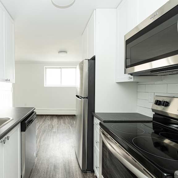 a kitchen with black countertops and white cabinets.