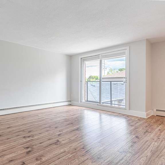 a room with wooden flooring and a sliding glass door.