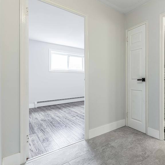 a bathroom with a white tile shower and a wooden floor.