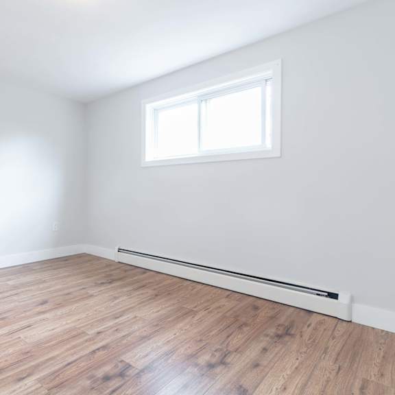 a room with a wooden floor and a window.