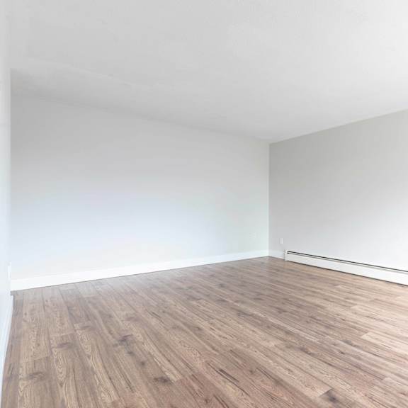 a room with wooden flooring and white walls.