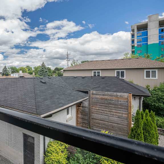 a view from a balcony overlooking a residential area with houses and trees.