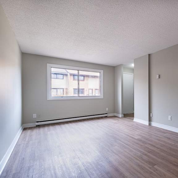 empty room with a window and wooden flooring.