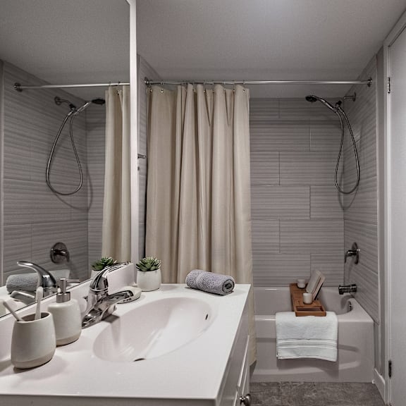 a white bathroom with a shower and sink.