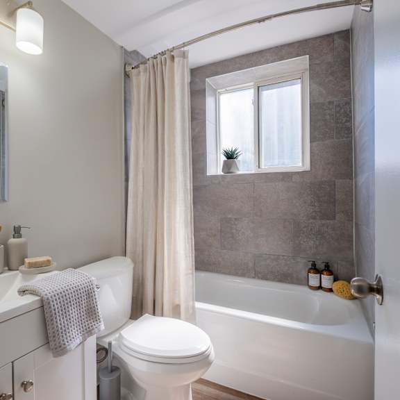 a bathroom with a white toilet, sink, and bathtub.