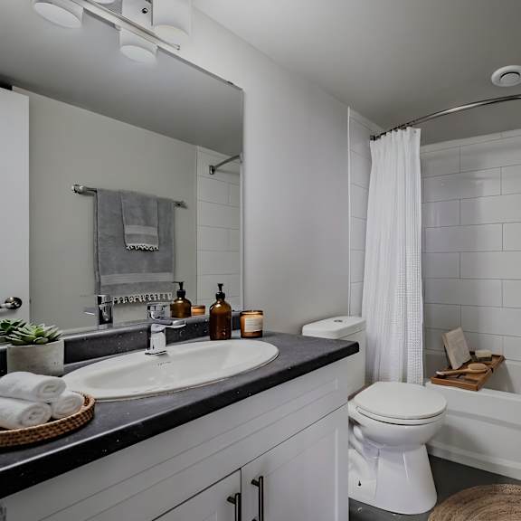 a bathroom with a white toilet, sink, and bathtub.