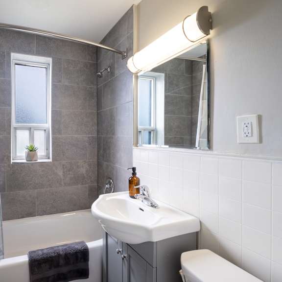 a bathroom with a white sink and a window with a curtain.