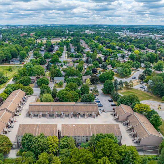 a large building complex surrounded by trees and a parking lot.