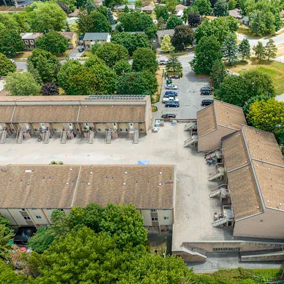 an aerial view of a parking lot and buildings surrounded by trees.