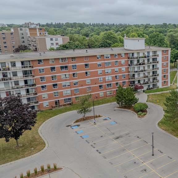 a parking lot is in the foreground of a large apartment complex.