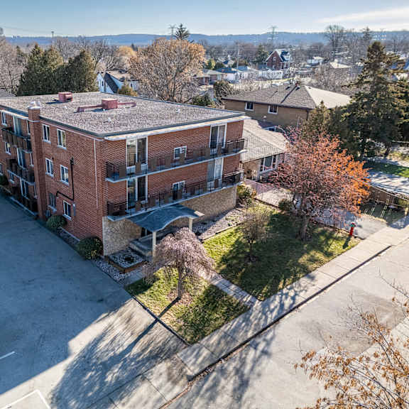 a parking lot is in front of a red brick apartment building.
