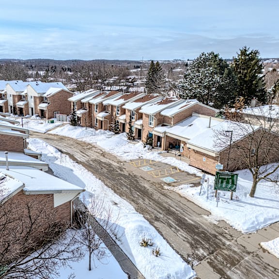 a snowy residential area with houses and trees.