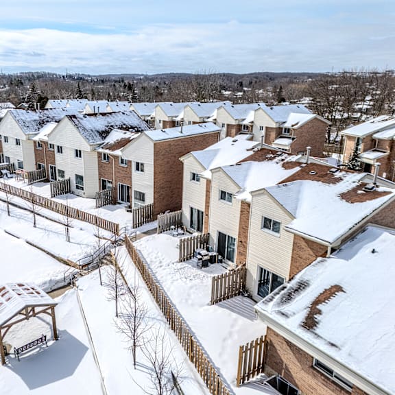 a snow-covered residential area with houses and a gazebo.