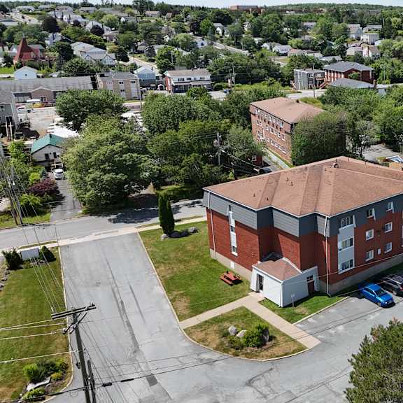 a red brick building with a parking lot in front.