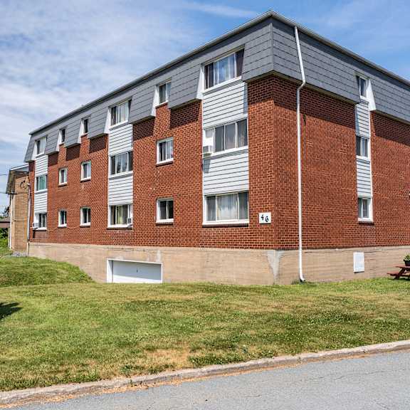 a red brick apartment building with a picnic table in front.