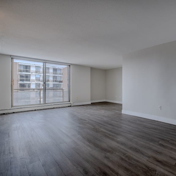 a room with wooden floors and a large window.