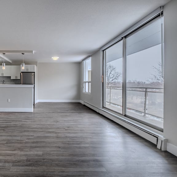 a large empty room with wooden floors and a large window.