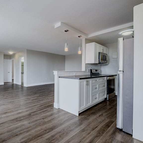 a kitchen with white cabinets and a black countertop.