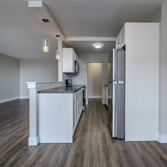 a long hallway with a kitchen area at the end.
