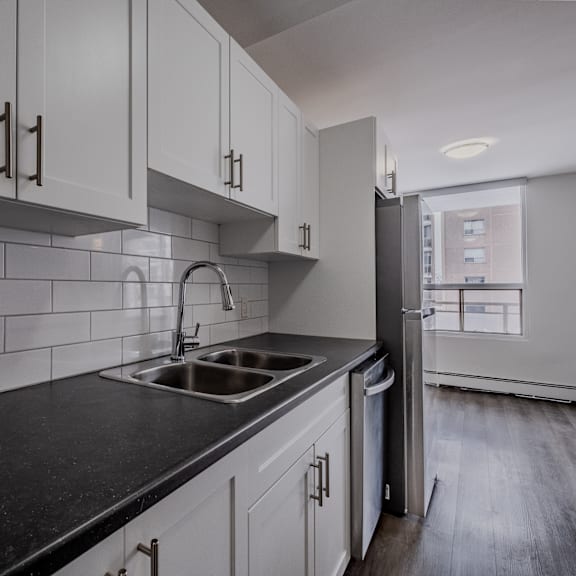 a kitchen with white cabinets and a black countertop.