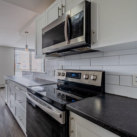 a modern kitchen with black countertops and white cabinets.