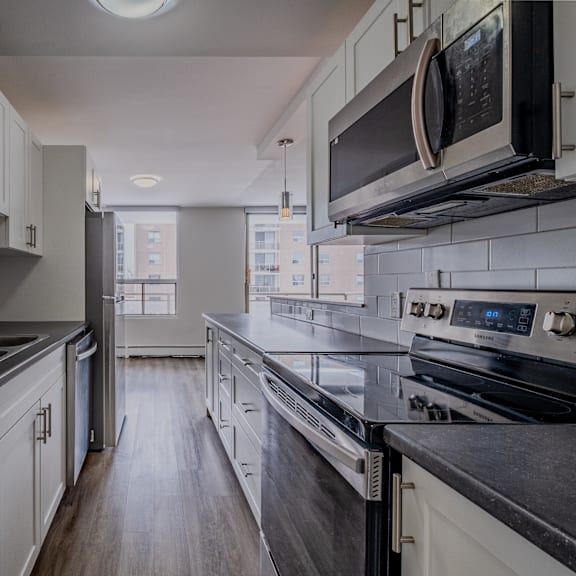 a modern kitchen with black countertops and white cabinets.
