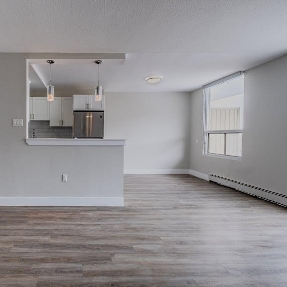 a kitchen with a wooden floor and white walls.
