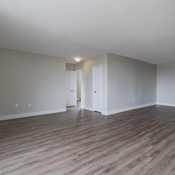 a room with wooden flooring and white walls.