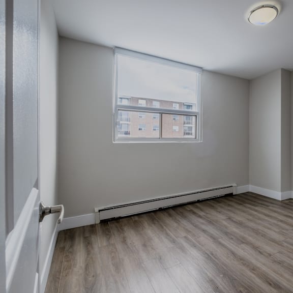 a room with a window and a view of a building across the street.