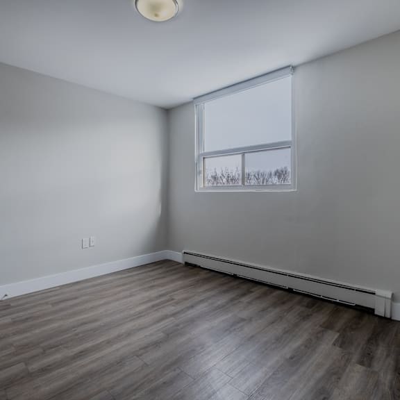 a room with a window and a wooden floor.