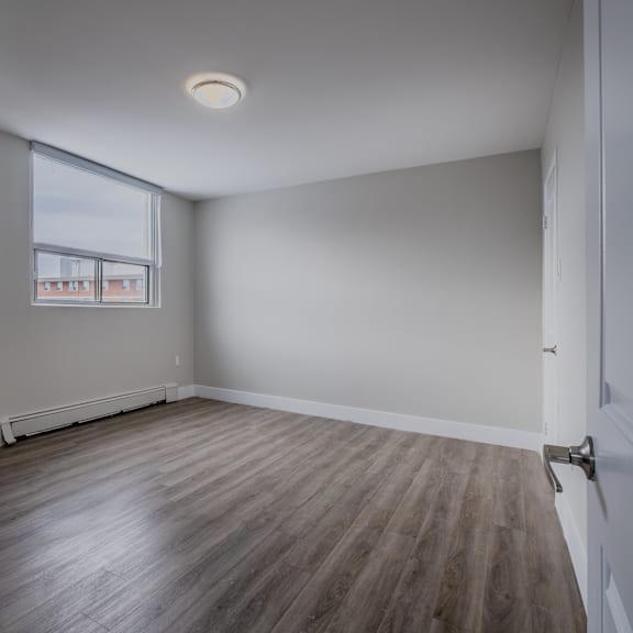 a room with wooden flooring and a window.