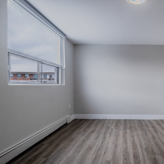 empty room with a window and wooden flooring.