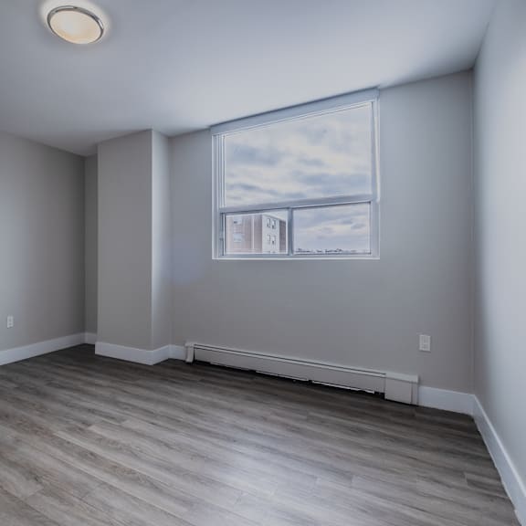 a room with a window and a wooden floor.