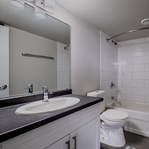 a white toilet is in a bathroom with a white tub.
