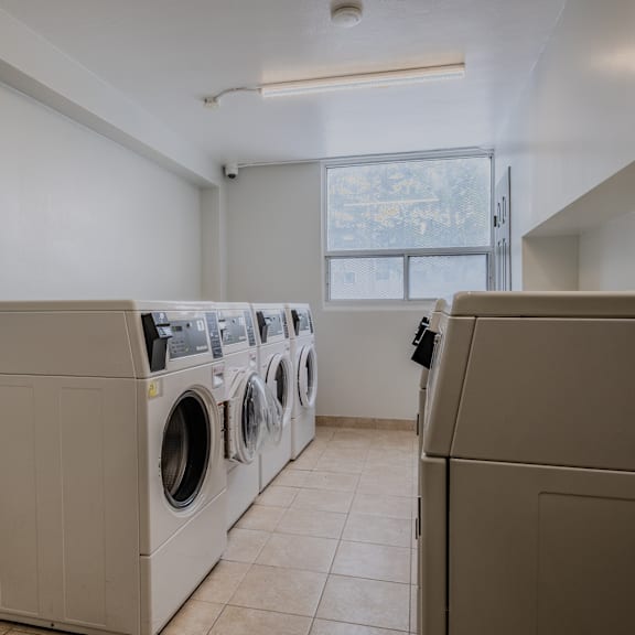 a laundry room with a row of washing machines.