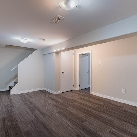 a room with a staircase and two doors.