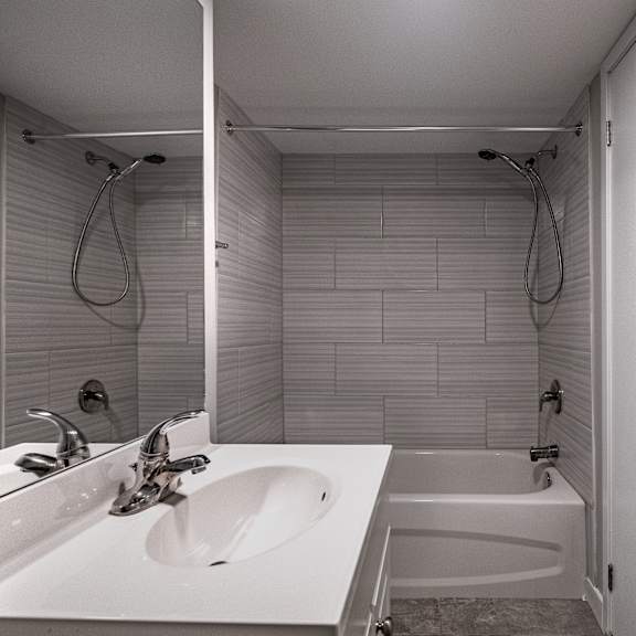 a white bathroom with a sink, mirror, and bathtub.