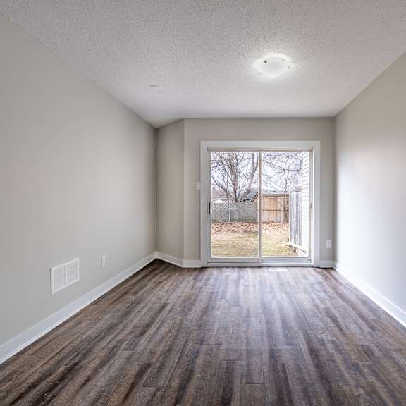a room with a brown floor and a white door.