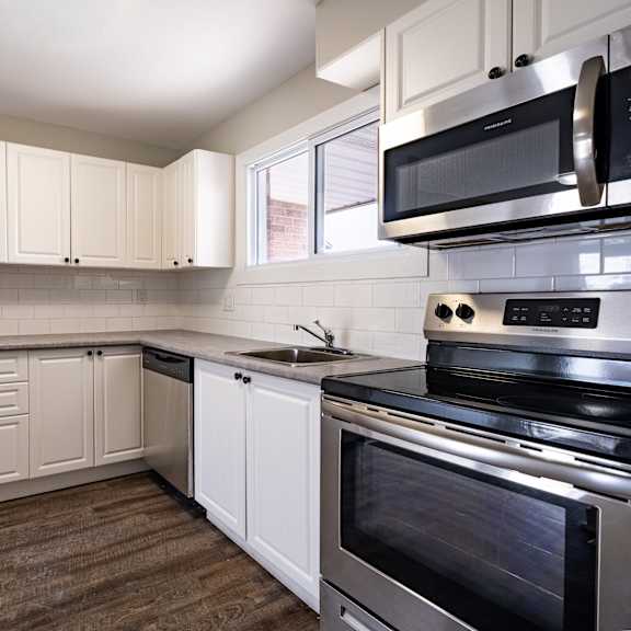 a kitchen with a stainless steel refrigerator, microwave, and oven.