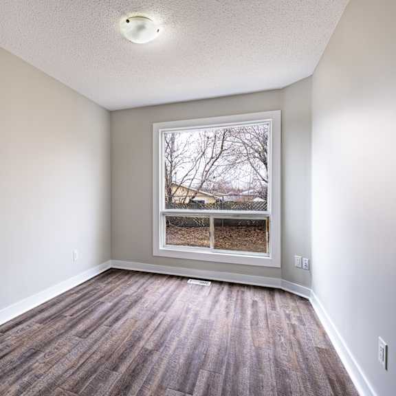 a room with a window and wooden flooring.