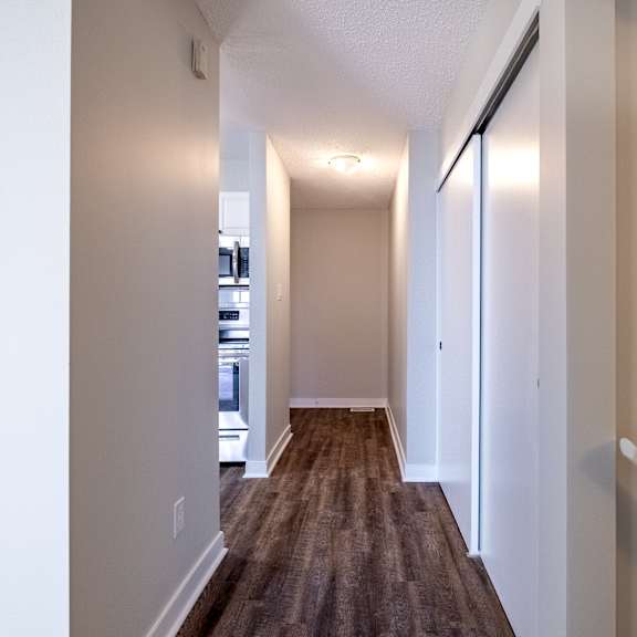 a long hallway with a brown carpet and white walls.