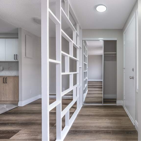 a white staircase with a wooden handrail leads to a bathroom.