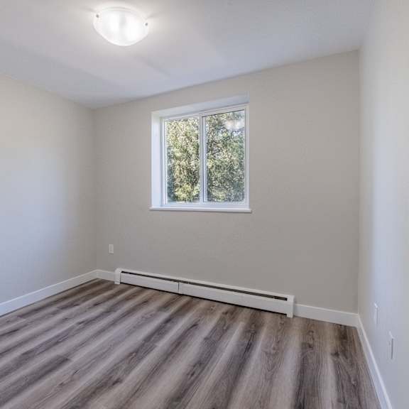 a room with a window and a wooden floor.
