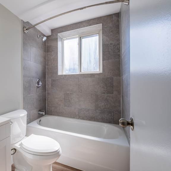a bathroom with a white toilet, sink, and bathtub.