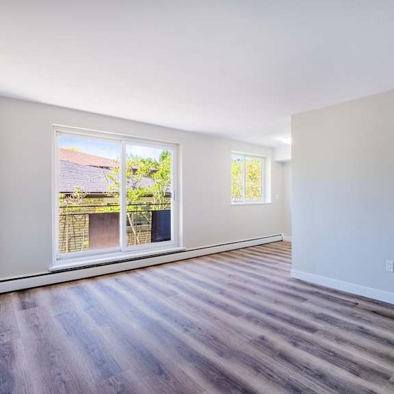 a room with a wooden floor and white walls.