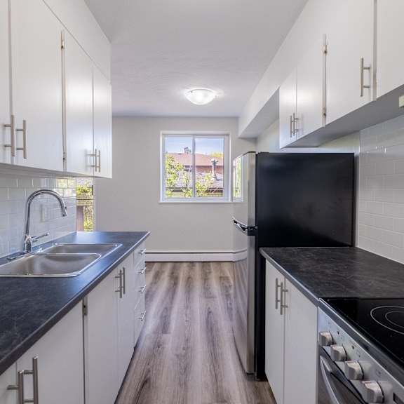a kitchen with black countertops and white cabinets.