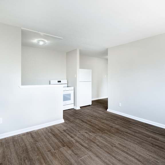 a room with a white wall and a brown floor.