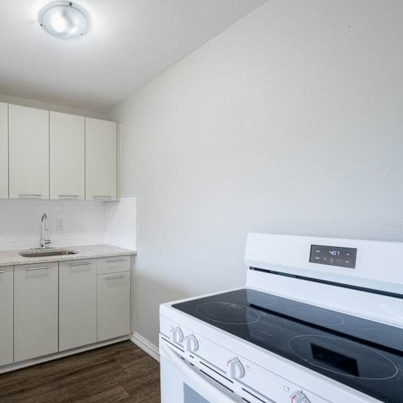 a white kitchen with a stove top oven.