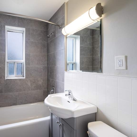 a bathroom with a white tub, sink, and toilet.